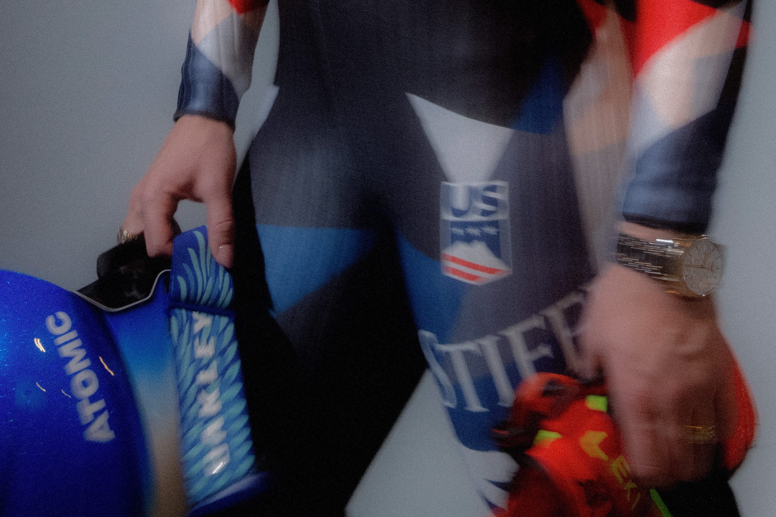 Close-up detail of Mikaela Shiffrin’s racing suit and wristwatch. The technical ski suit features performance-focused fabric, sponsor branding, and bold design elements, highlighting its athletic construction. A watch is visible on her wrist, emphasizing precision, durability, and the connection between elite performance and timing in competitive alpine skiing.