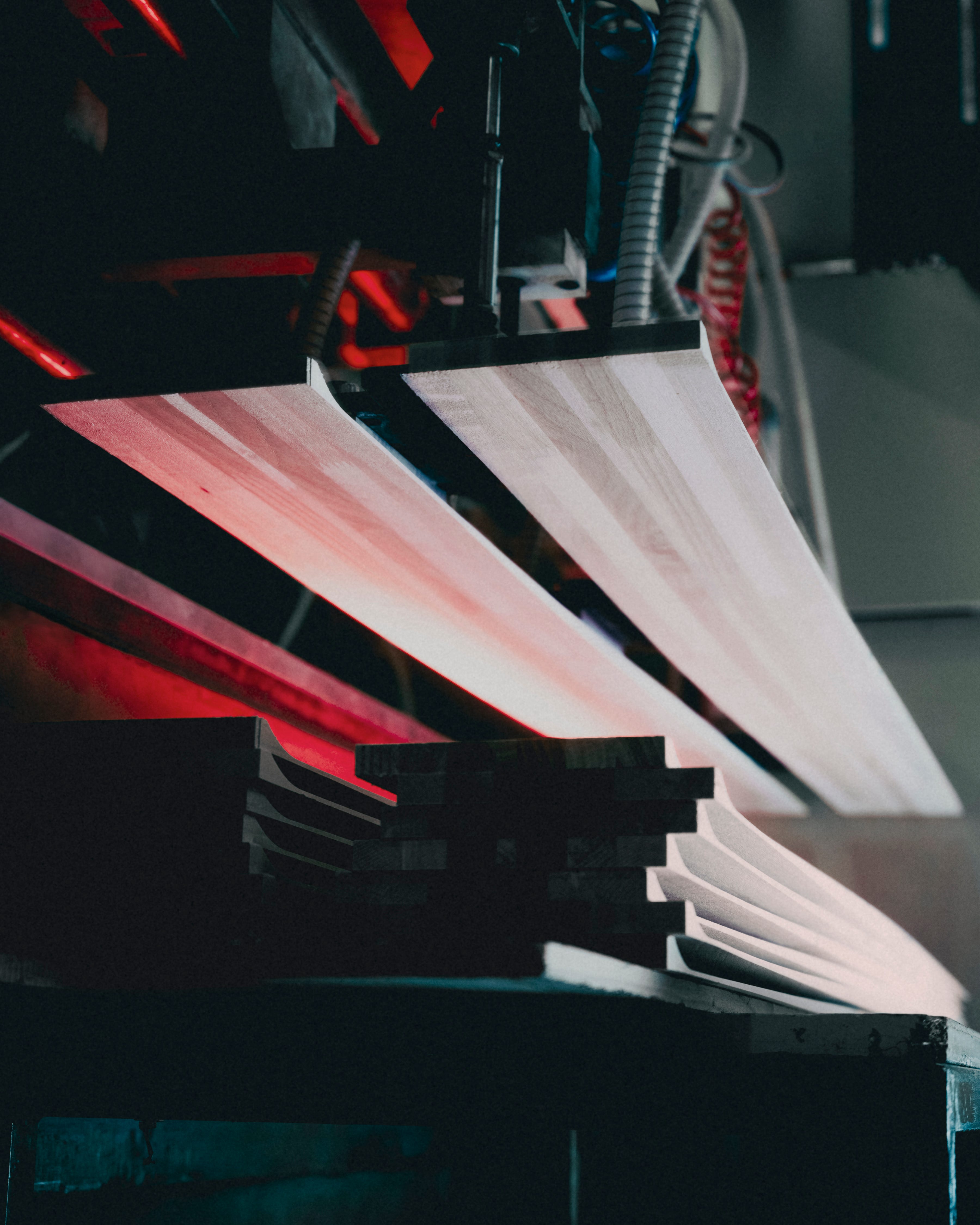 A close-up view of a Redster 13 oarranged in a fan-like stack, with dark machinery and red lighting visible in the background.