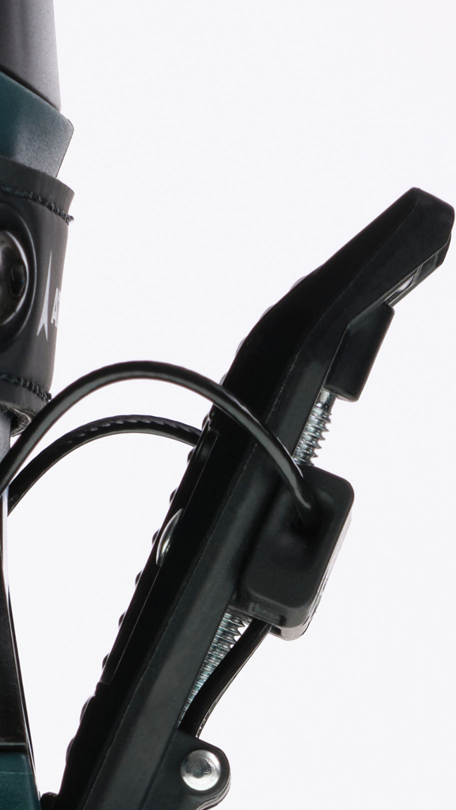 Close-up detail of a ski boot binding device with black plastic components, a dark teal boot shell, and a black strap on a clean white background.