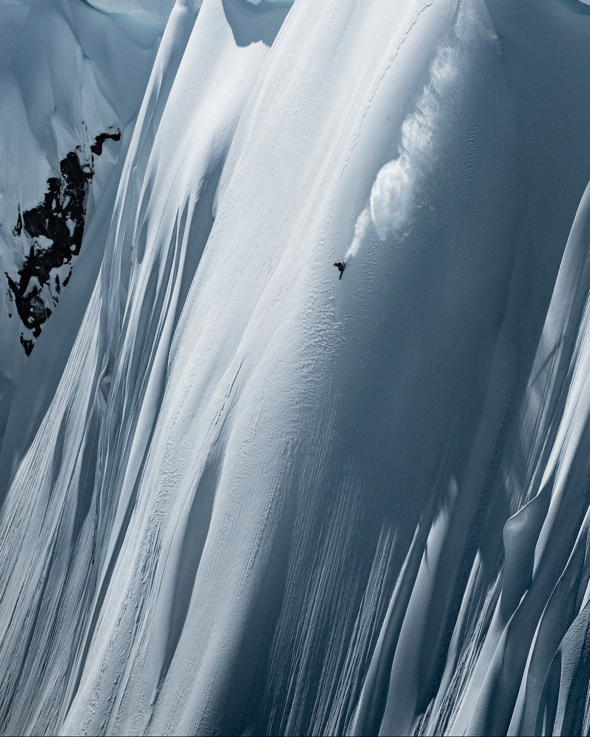 Nick Mcnutt carving down a steep mountain ridge. 